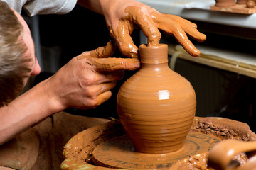 hands of a potter, creating an earthen jar