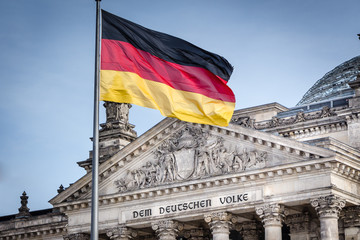 Fototapeta premium Niemiecka flaga przed Reichstagiem - niemieckim parlamentem