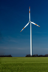 wind mill on a green meadow with dark blue sky