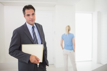 Well dressed real estate agent with blurred woman in background