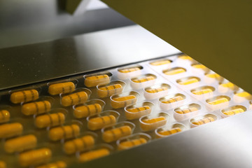 Yellow capsules packed in tablet packing machine