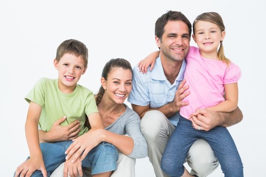 Cute family posing and smiling at camera together