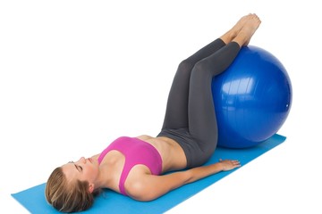 Full length of a fit woman exercising with fitness ball