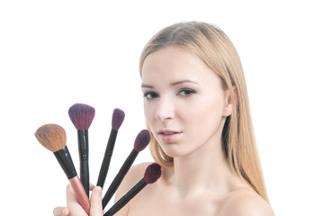 Beauty photo of girl with five makeup brushes.