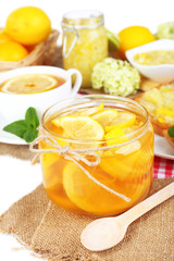 Tasty lemon jam with cup of tea on table close-up