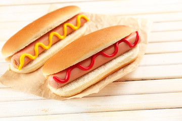 Tasty hot dogs on wooden table