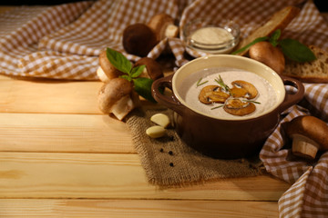 Obraz na płótnie Canvas Mushroom soup in pot, on napkin, on wooden background