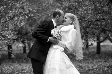 portrait of bride and groom kissing at park