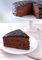 Delicious chocolate cake on plate on table on light background