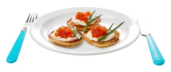 Pancakes with red caviar on plate, isolated on white