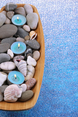 Wooden bowl with Spa stones, sea shells and candles