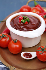 Tomato sauce in bowl on wooden table close-up