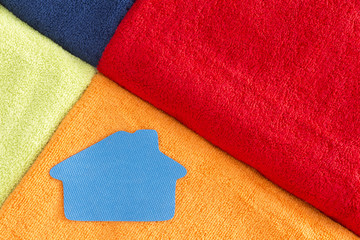 Colorful soft luxurious towels with a house icon