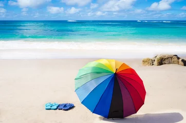 Abwaschbare Fototapete Summer background with rainbow umbrella and flip flops © ellensmile