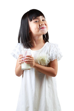 Happy little asian girl holding a cup of milk
