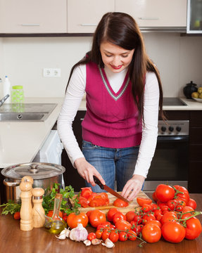 brunette long-haired housewife cooking with  tomatoes