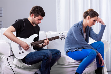 Rockman playing guitar and bored woman
