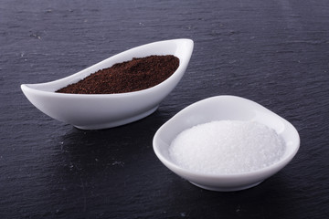 Sugar and coffee in two little white ceramic bowls