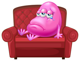A crying monster sitting on a red sofa