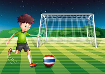 A soccer player kicking the ball with the flag of Thailand