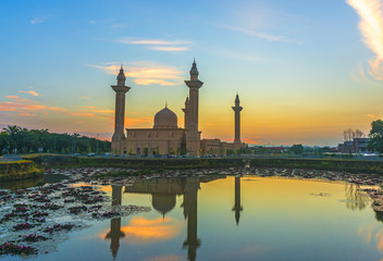 Mosque and sunrise reflection on lake