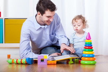 Father viewing photo album with son