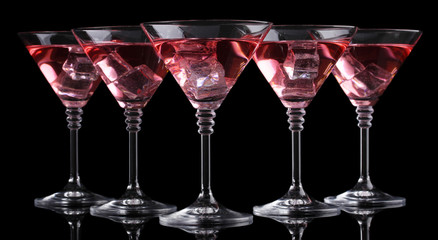 Red cocktail in martini glasses isolated on black