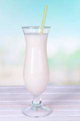Milk shake on table on light blue background