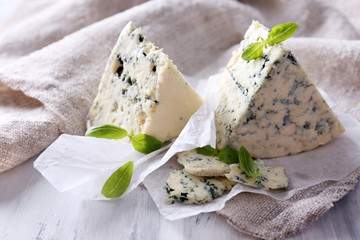 Tasty blue cheese with basil on paper