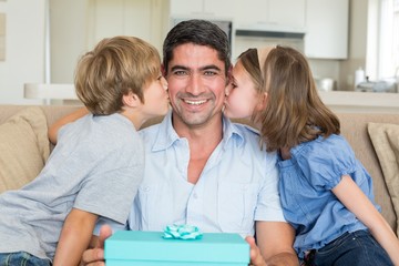 Children kissing on fathers cheeks