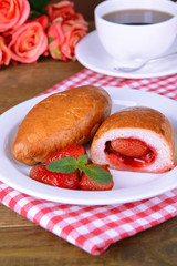Fresh baked pasties with strawberries on plate on table
