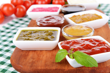 Various sauces on chopping board on table close-up