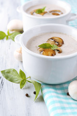 Mushroom soup in white pots, on napkin,  on wooden background