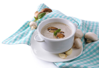 Mushroom soup in white pot, on napkin, isolated on white