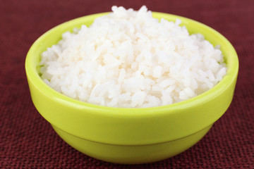 Cooked rice in bowl on red background