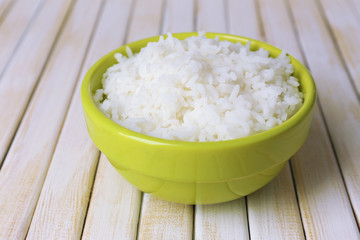 Cooked rice in bowl on wooden background