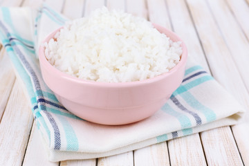 Cooked rice in bowl on wooden background