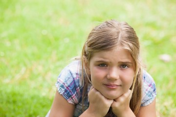 Fototapeta premium Close-up of a cute girl lying on grass at park