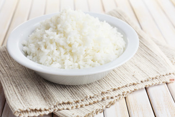Cooked rice in bowl on wooden background
