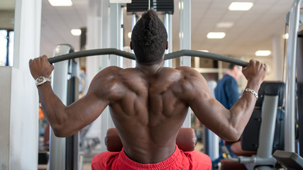 Strong young black man exercising at the gym.