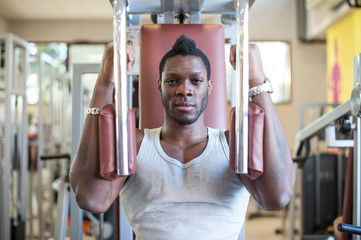 Strong young black man exercising at the gym.