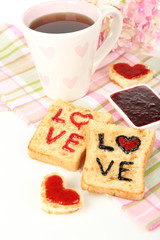 Delicious toast with jam and cup of tea on table close-up