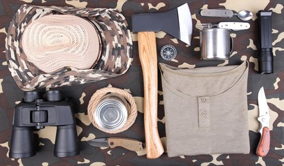 Equipment for trekking on camouflage background