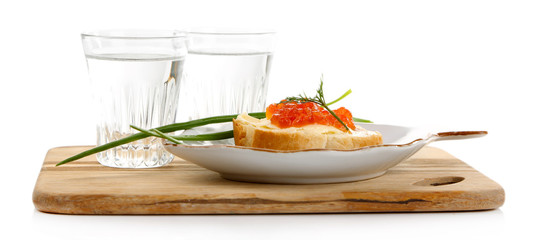 Sandwich with caviar and vodka on wooden board isolated on