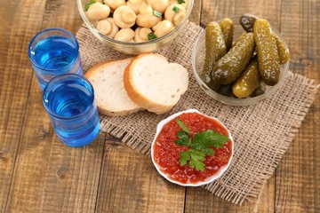 Composition with glass of vodka and marinated mushrooms,