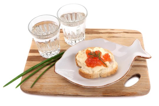 Sandwich with caviar and vodka on wooden board isolated on