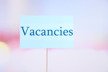 Nameplate with inscription Vacancies on bright background