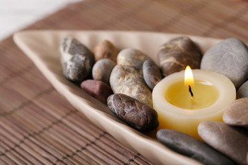 Fototapeta na wymiar Spa stones and candle in decorative bowl,