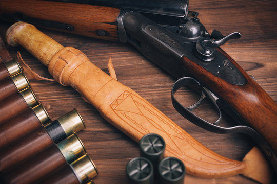 Shotgun with shells on wooden background