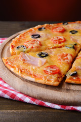 Tasty pizza on table on dark red background